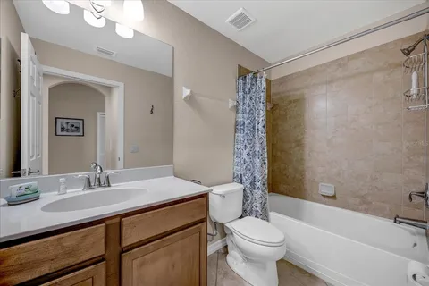 a bathroom with a sink a toilet a mirror a vanity and bathtub