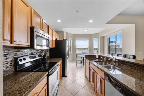 a kitchen with stainless steel appliances granite countertop a stove a sink and a refrigerator