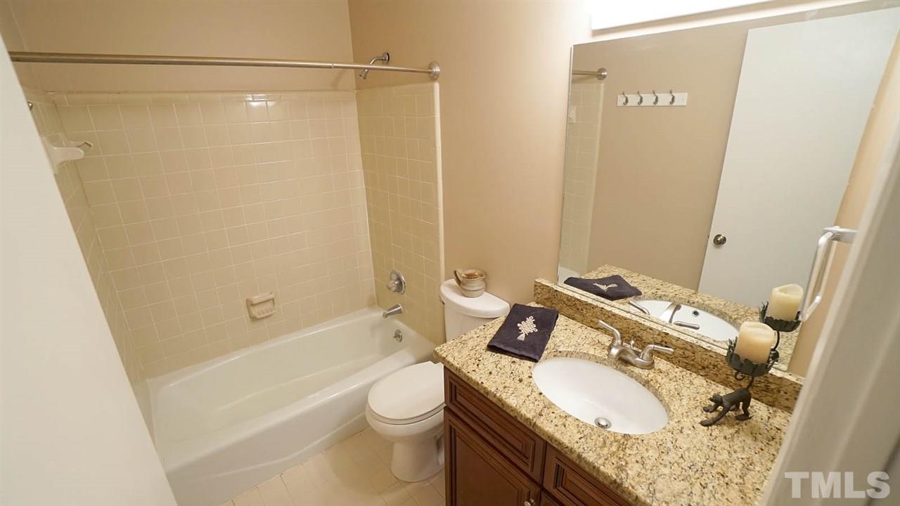 4301 Sun Belt Place Raleigh, NC 27613 - Photo 18 of 23 Hall Bathroom has updated, Mirrored Vanity with Granite Countertop + Ceramic Tile Surround Shower/Tub Combo + Ceramic Floor