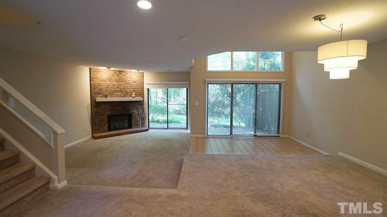 4301 Sun Belt Place Raleigh, NC 27613 - Photo 6 of 23 Sunken Living Room has corner Brick Fireplace with Gas Logs + Sliding Glass Doors so you can Enjoy the View of Nature at its Finest.