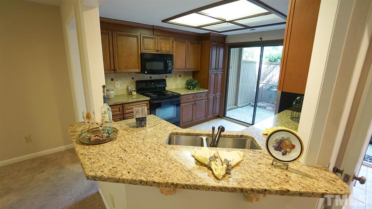 4301 Sun Belt Place Raleigh, NC 27613 - Photo 9 of 23 Kitchen is Separated from Living and Dining Room by an Eat-at Bar and Pass Thru Window
