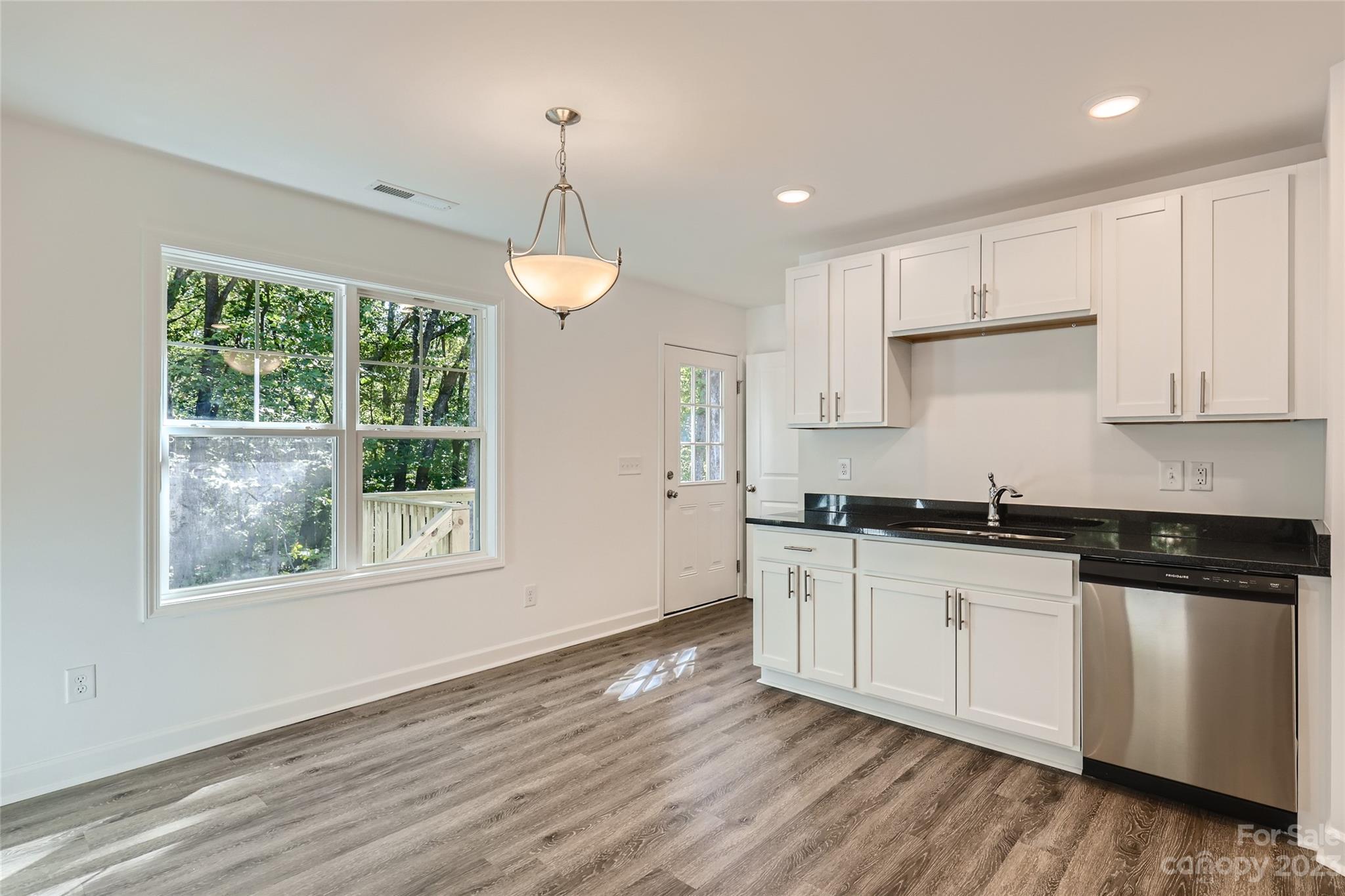 626 Colston Street Albemarle, NC 28001 - Photo 4 of 11 a kitchen with granite countertop a stove a sink a refrigerator and white cabinets with wooden floor