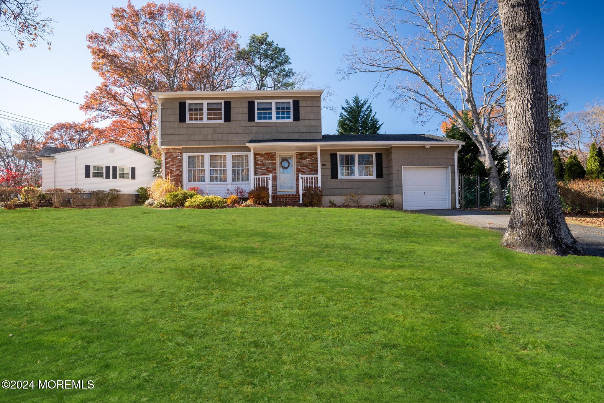 118 Charleson Road Brick, NJ 08724 - Photo 3 of 30 a house that is sitting in the grass with large trees and plants