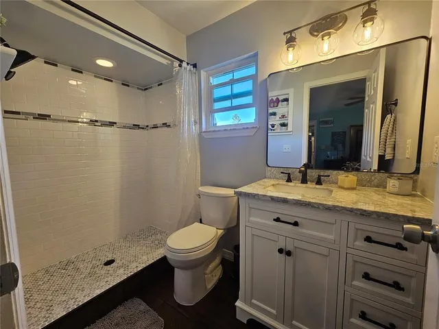 a view of a kitchen with kitchen island granite countertop lots of counter top space and refrigerator