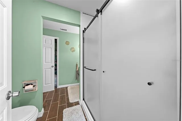 a large living room with stainless steel appliances wooden floor and chandelier