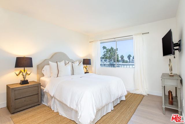 a bedroom with a bed and a flat screen tv