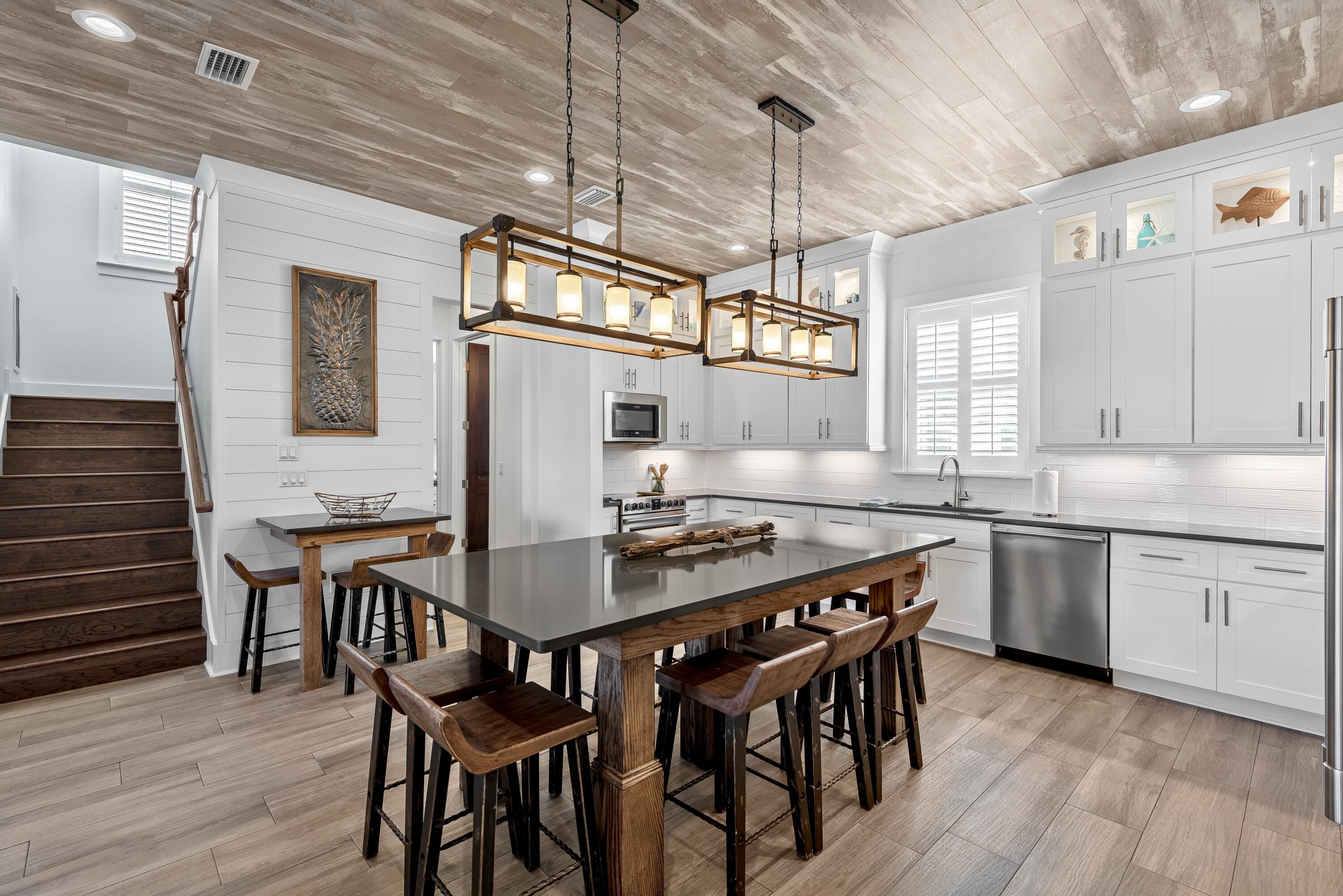 63 Wadleigh Way Miramar Beach, FL 32550 - Photo 9 of 42 a kitchen with stainless steel appliances granite countertop a kitchen island a stove a table and chairs in it