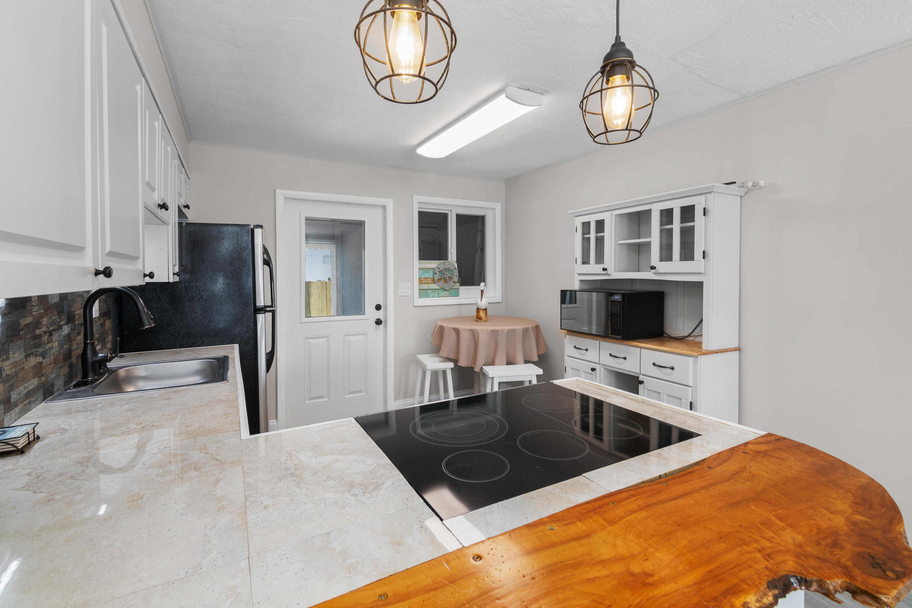 10873 7th Ave Gulf Marathon, FL 33050 - Photo 17 of 25 a kitchen with stainless steel appliances granite countertop a sink refrigerator stove and microwave