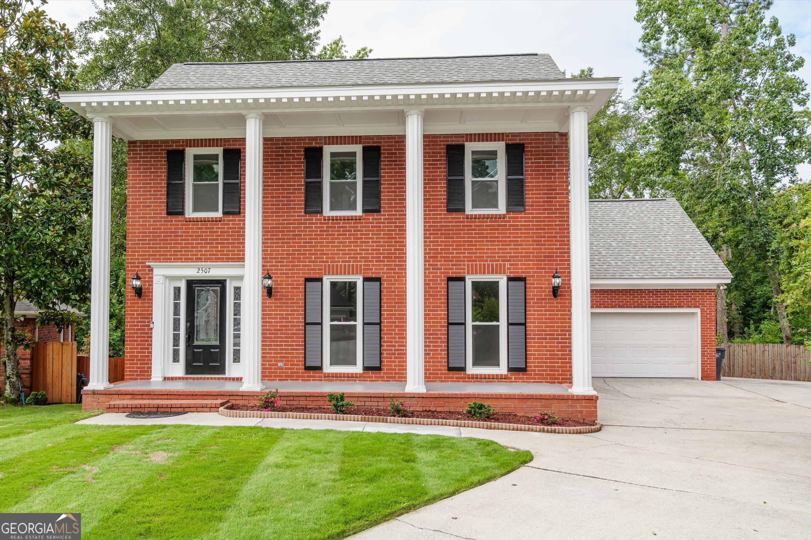 front view of a brick house with a yard