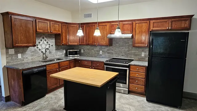 a kitchen with a sink refrigerator and cabinets