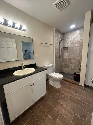 a bathroom with a toilet sink and a mirror