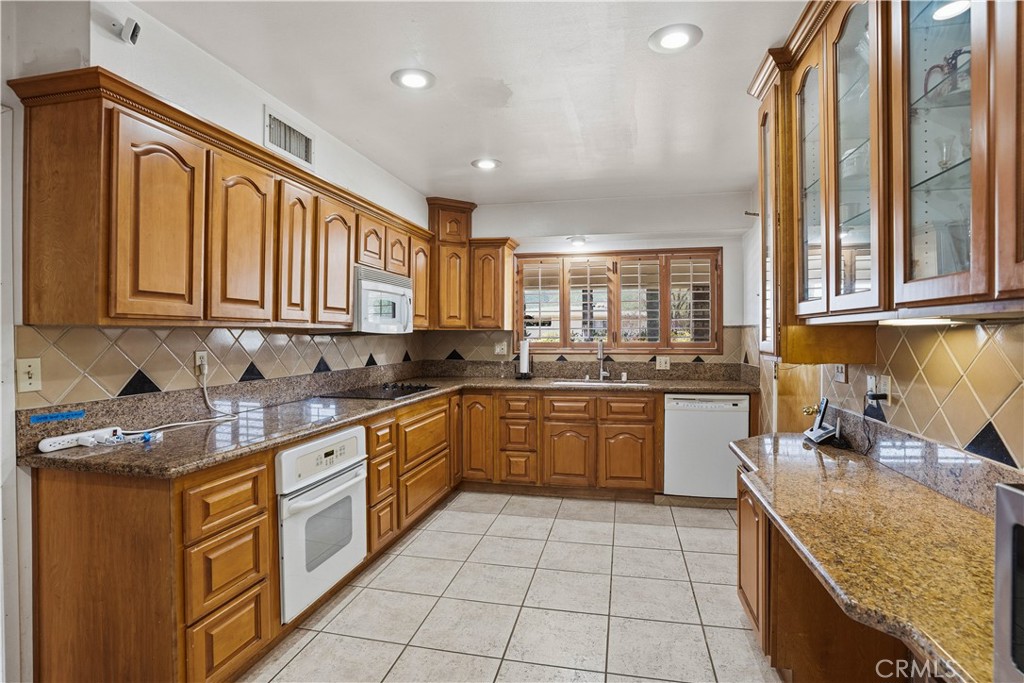 25990 Roanoke Road Menifee, CA 92586 - Photo 14 of 47 a kitchen with stainless steel appliances granite countertop a sink stove and cabinets
