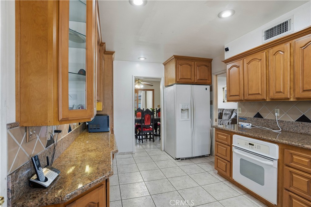 25990 Roanoke Road Menifee, CA 92586 - Photo 15 of 47 a kitchen with stainless steel appliances granite countertop a refrigerator and a stove