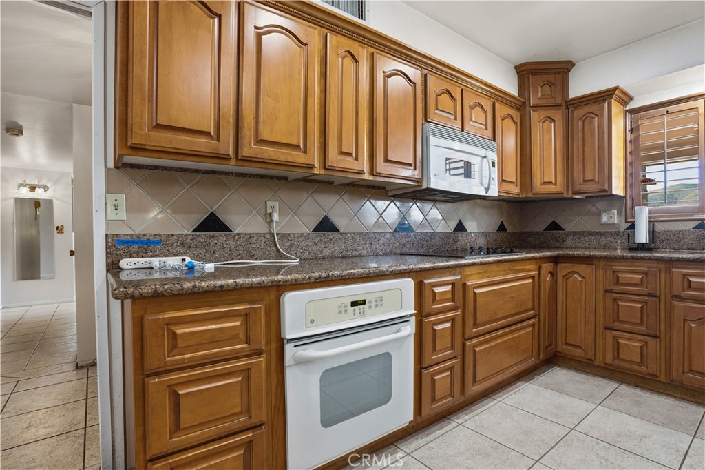 25990 Roanoke Road Menifee, CA 92586 - Photo 17 of 47 a kitchen with stainless steel appliances granite countertop a sink and cabinets