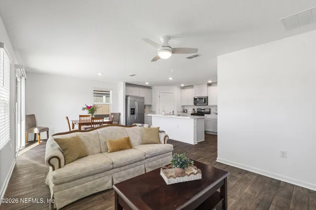 a living room with furniture and kitchen view