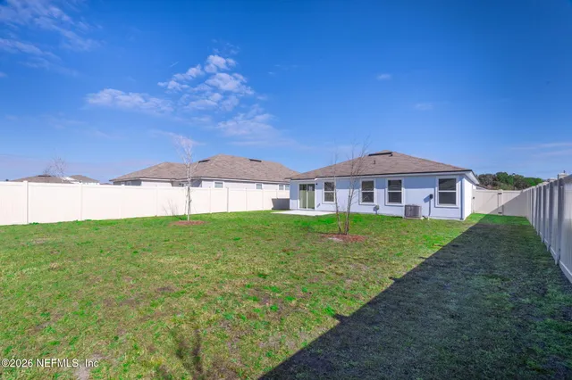 a view of a house next to a yard with big trees