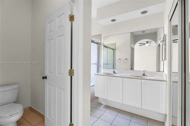 a bathroom with a granite countertop sink mirror and toilet