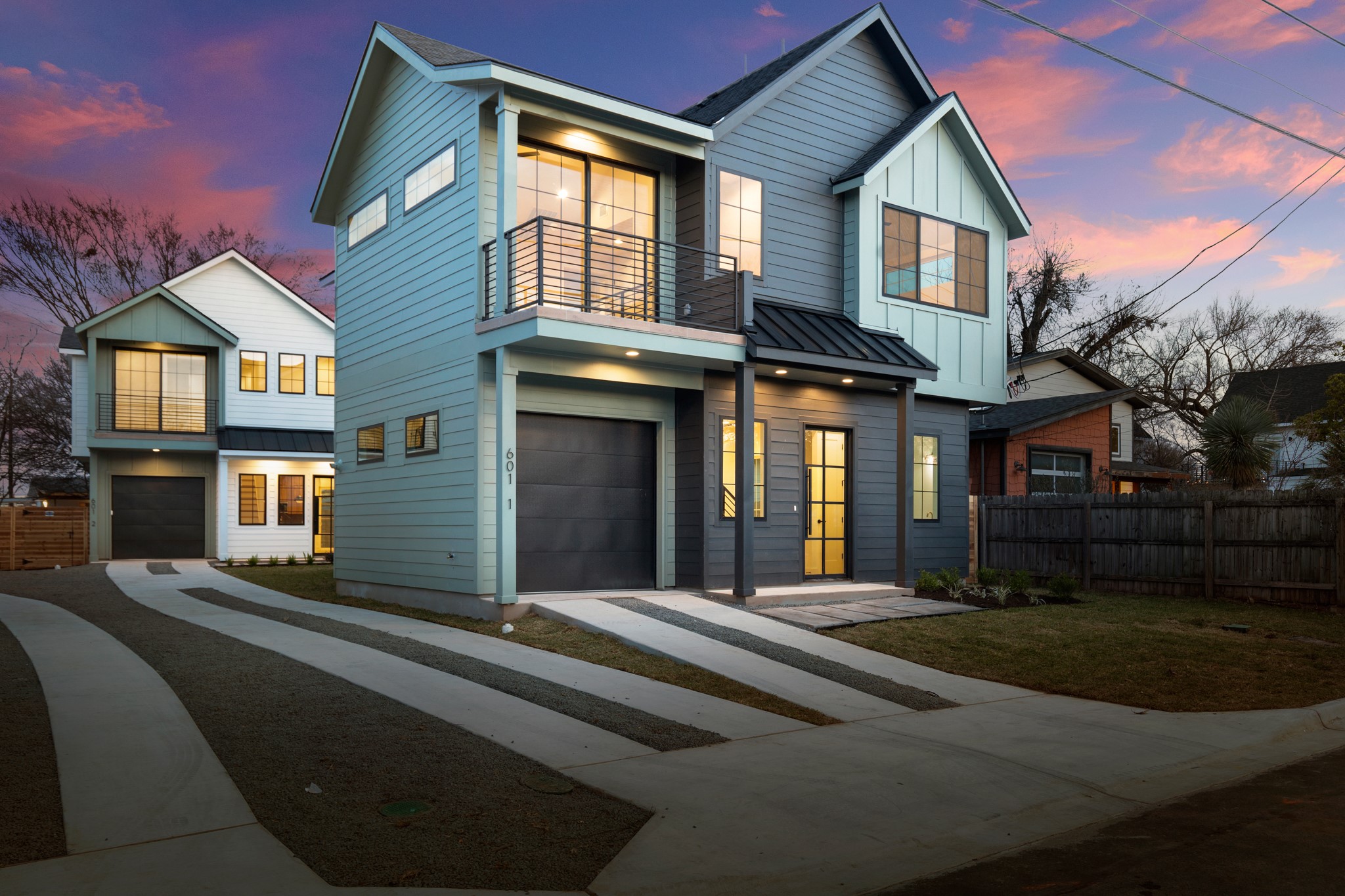 601 Vermont Road, Unit 1 Austin, TX 78702 - Photo 1 of 14 Contemporary home featuring a balcony, an attached garage, a standing seam roof, driveway, and board and batten siding