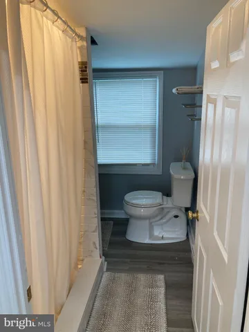 a bathroom with a toilet and a shower curtain