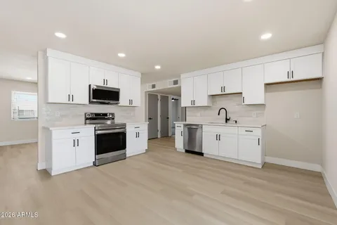 a kitchen with granite countertop white cabinets stainless steel appliances and sink