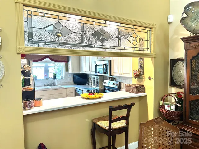 a view of a dining room with furniture a chandelier and wooden floor