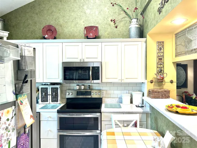 a kitchen with stainless steel appliances a stove a sink and a microwave