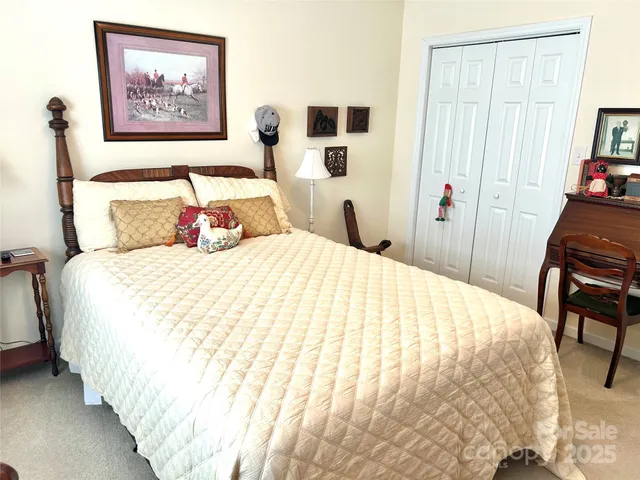 a bedroom with bed and a painting on the wall