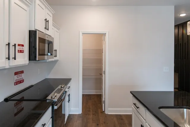 a kitchen with stainless steel appliances granite countertop a refrigerator and a stove top oven