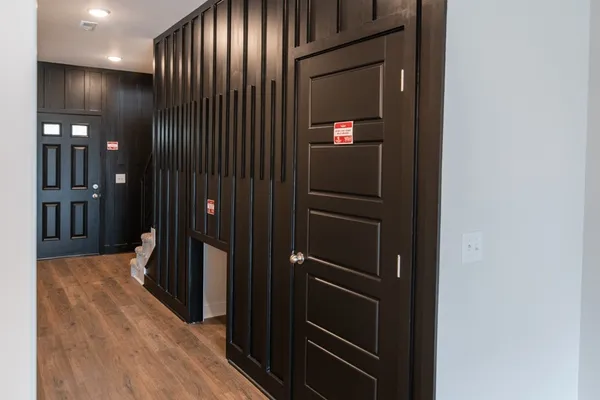 a view of a hallway with wooden floor and staircase