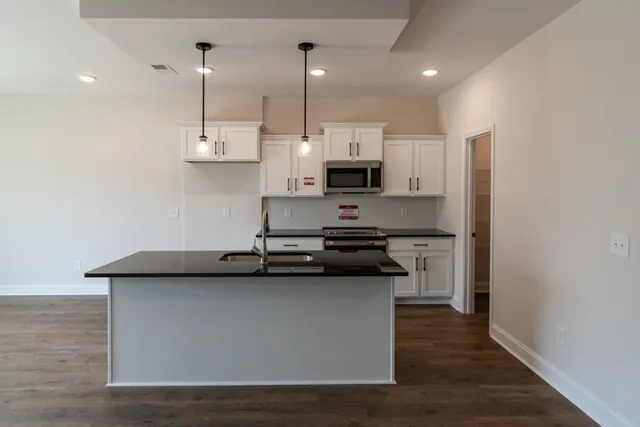 a kitchen with stainless steel appliances granite countertop a sink a stove and a refrigerator