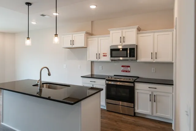 a kitchen with stainless steel appliances granite countertop a sink and a stove