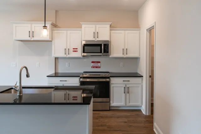 a kitchen with stainless steel appliances granite countertop a sink and a stove