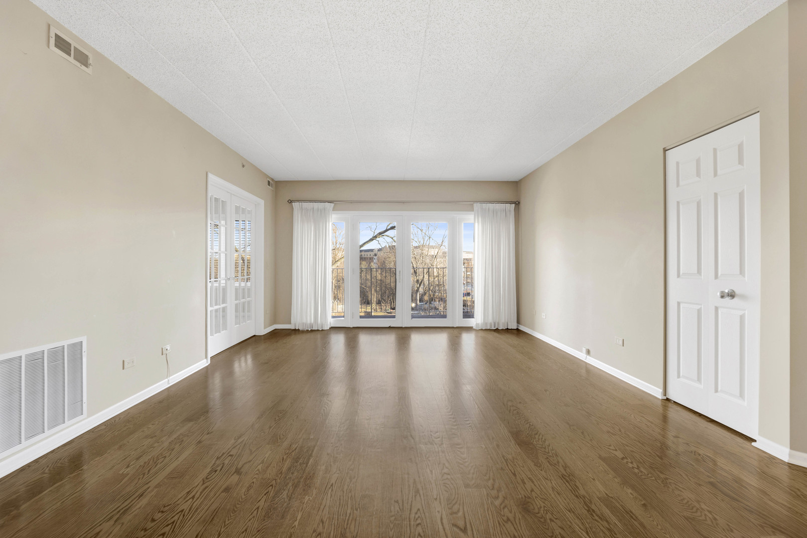 201 West Brush Hill Road, Unit 203 Elmhurst, IL 60126 - Photo 2 of 24 an empty room with wooden floor and windows