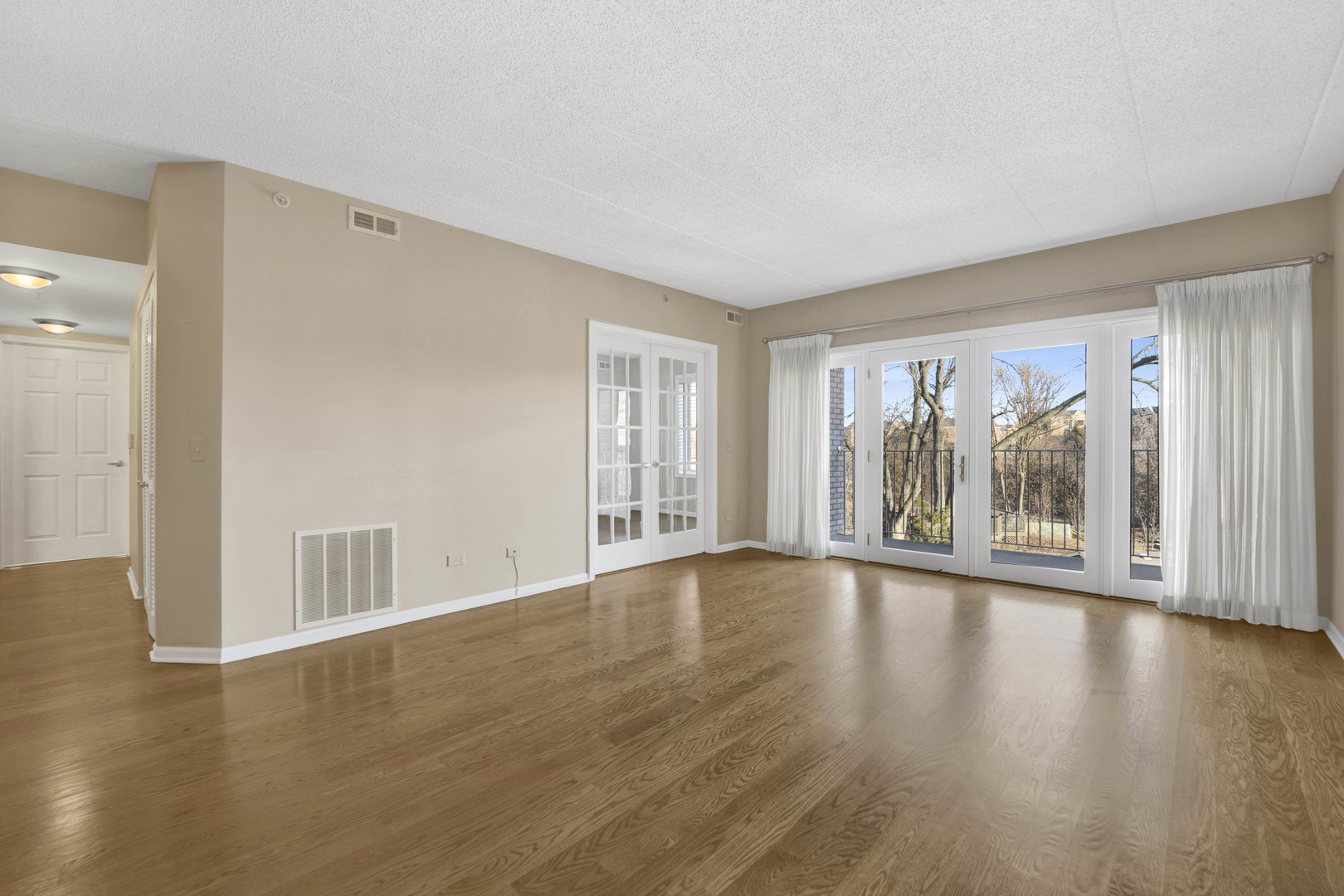 201 West Brush Hill Road, Unit 203 Elmhurst, IL 60126 - Photo 3 of 24 a view of an empty room with wooden floor and a window
