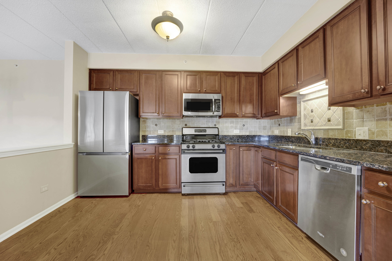 201 West Brush Hill Road, Unit 203 Elmhurst, IL 60126 - Photo 8 of 24 a kitchen with granite countertop a refrigerator stove top oven and sink
