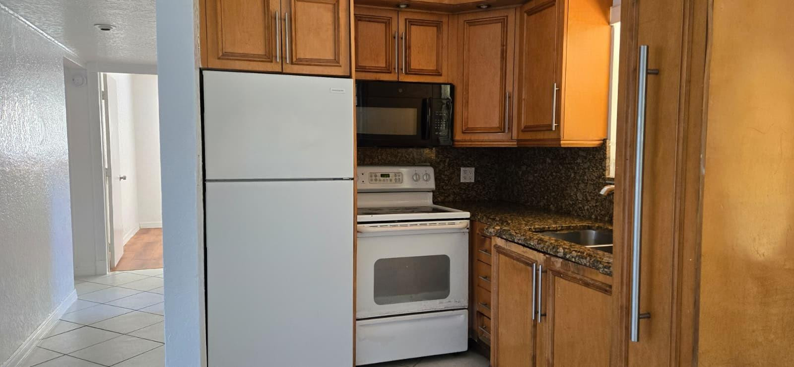 112 Newton Road West Park, FL 33023 - Photo 5 of 31 a kitchen with a refrigerator sink and cabinets