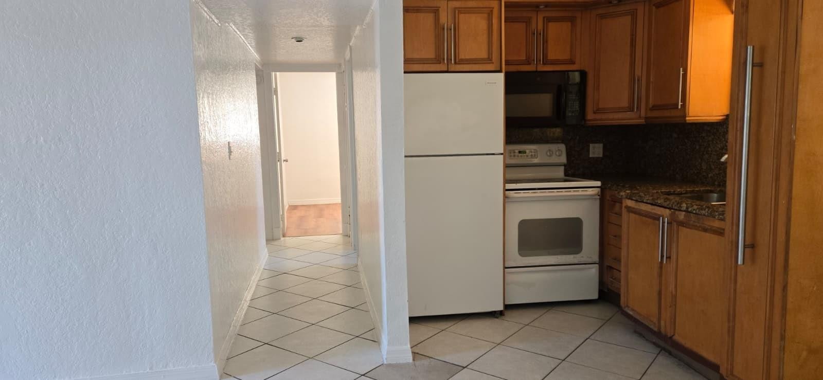 112 Newton Road West Park, FL 33023 - Photo 7 of 31 a kitchen with a refrigerator sink and cabinets