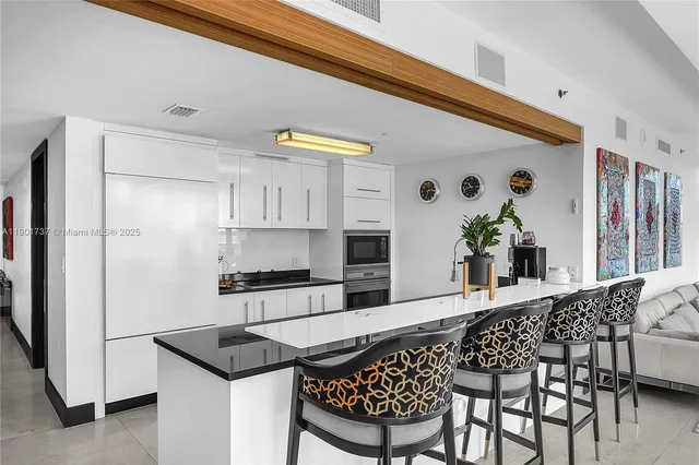 a kitchen with stainless steel appliances kitchen island granite countertop a refrigerator and a stove