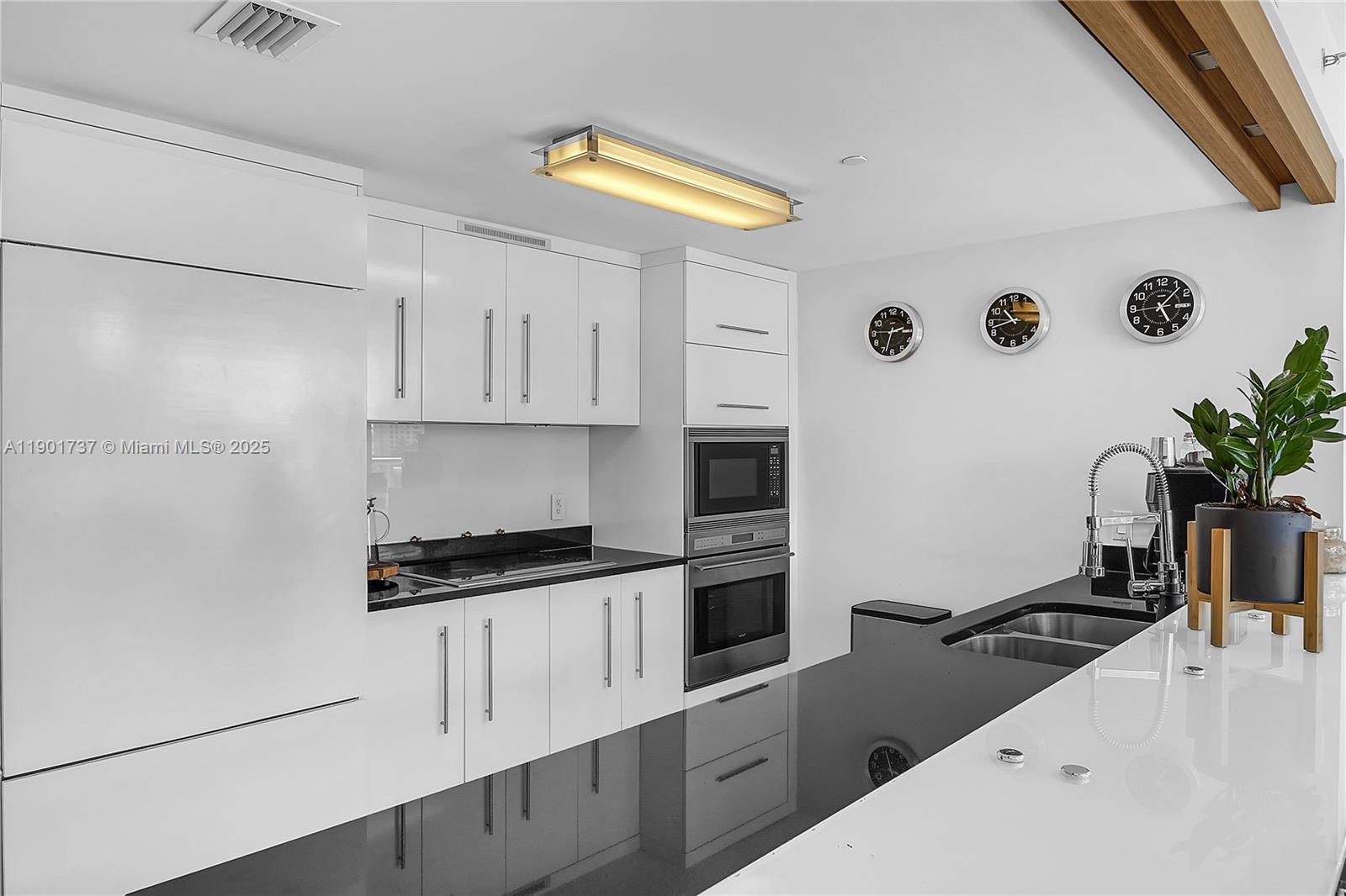 465 Brickell Avenue, Unit 1001 Miami, FL 33131 - Photo 13 of 42 a kitchen with granite countertop a sink a stove and refrigerator