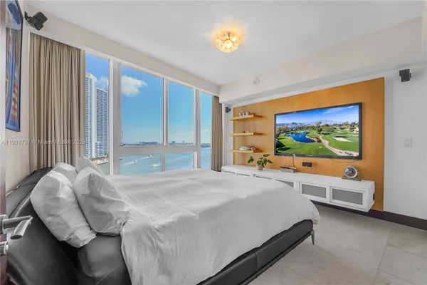 a bedroom with a bed and a large window