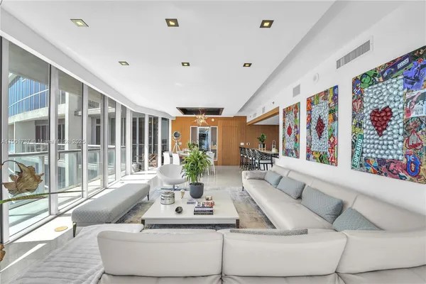 a living room with furniture and large windows