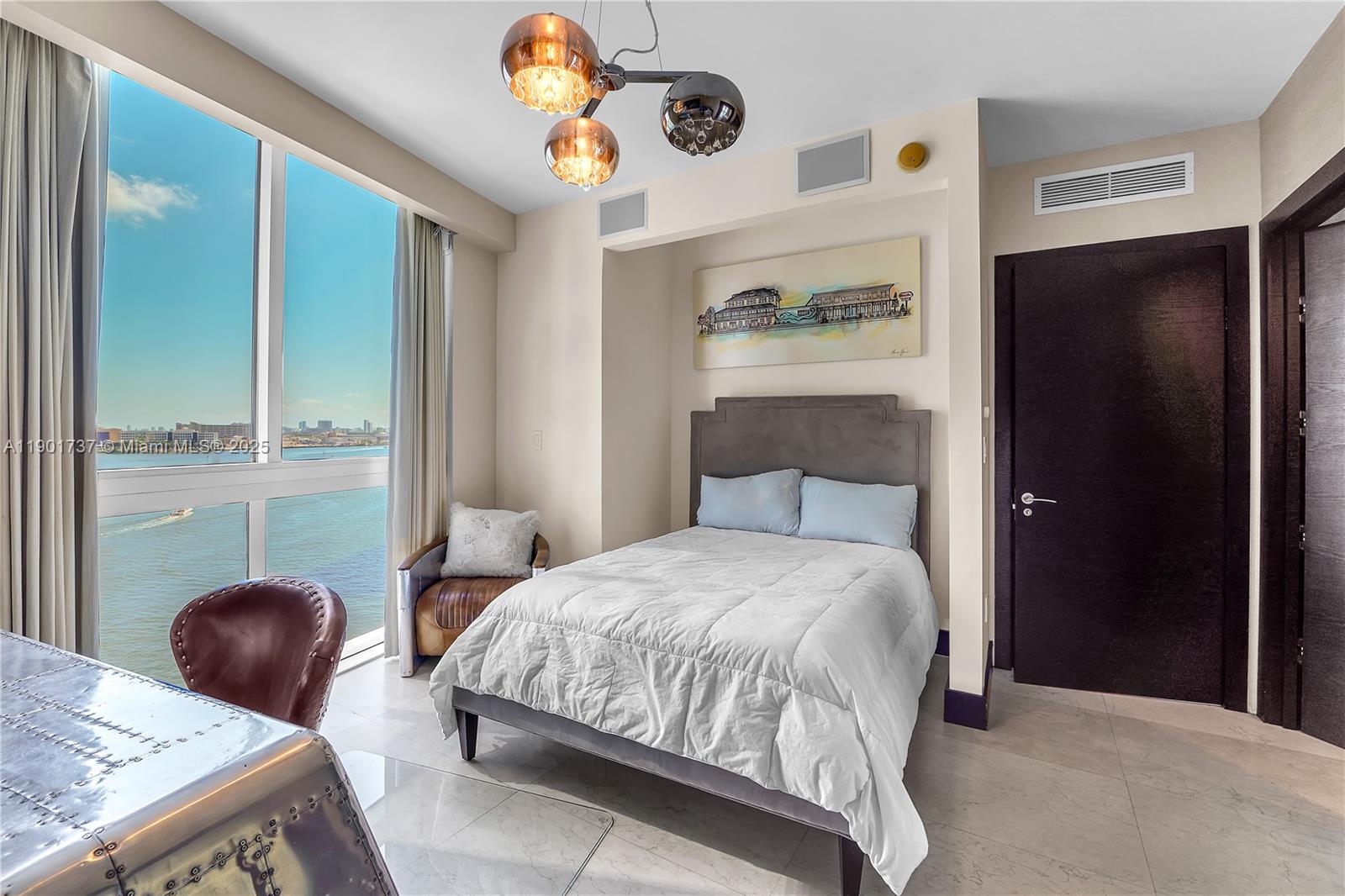 465 Brickell Avenue, Unit 1001 Miami, FL 33131 - Photo 33 of 42 a bedroom with a bed a chandelier and dresser