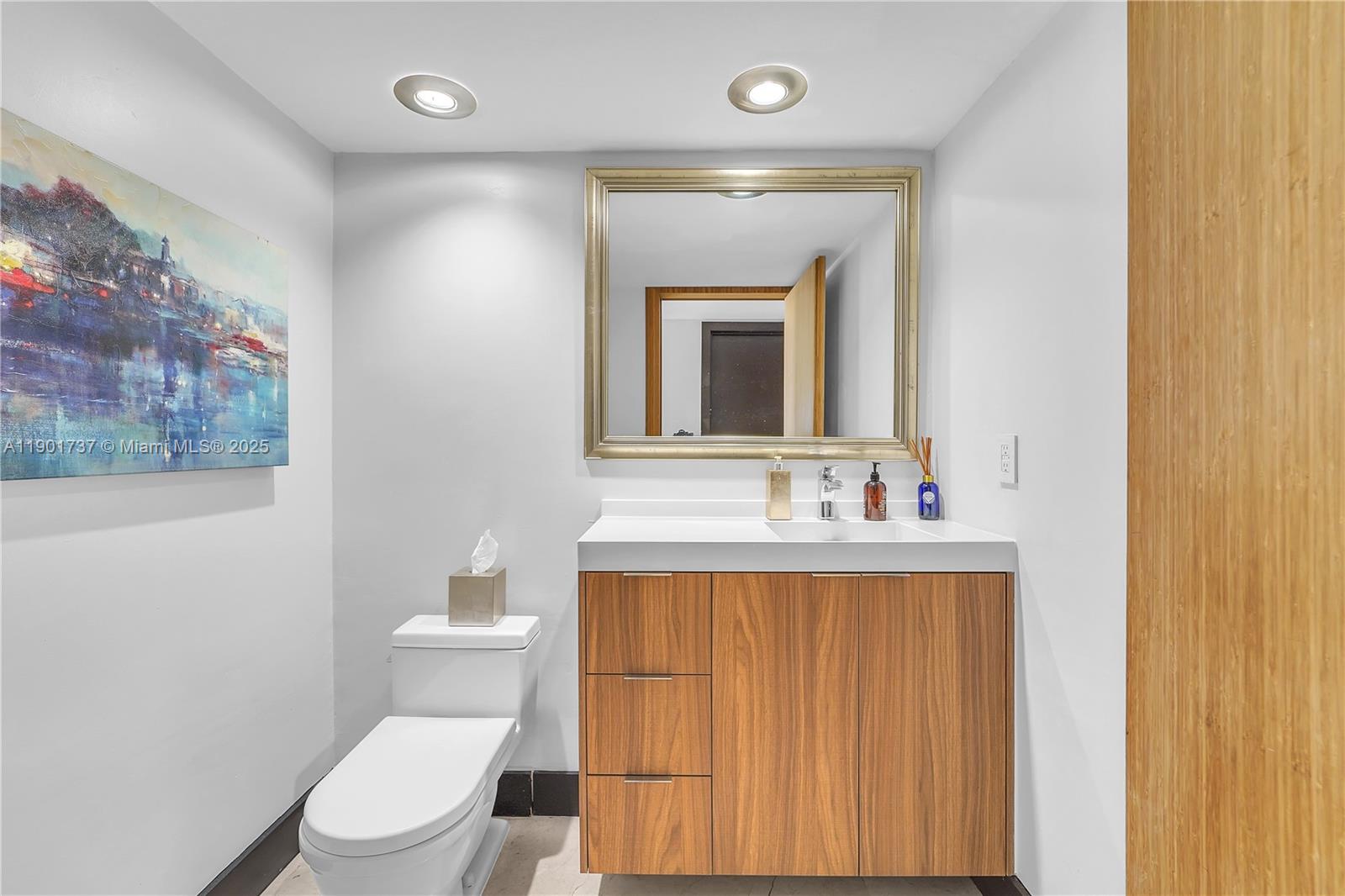465 Brickell Avenue, Unit 1001 Miami, FL 33131 - Photo 35 of 42 a bathroom with a toilet a sink a mirror and a window