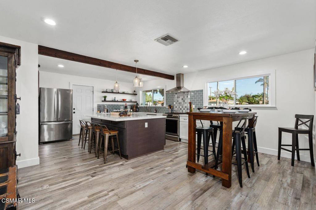1135 Donner Avenue Simi Valley, CA 93065 - Photo 8 of 48 a kitchen with stainless steel appliances kitchen island granite countertop a table chairs and a refrigerator