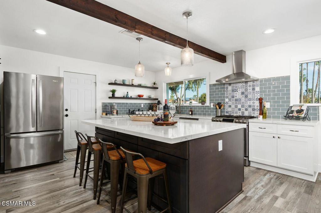 1135 Donner Avenue Simi Valley, CA 93065 - Photo 9 of 48 a kitchen with stainless steel appliances granite countertop a table chairs stove and refrigerator