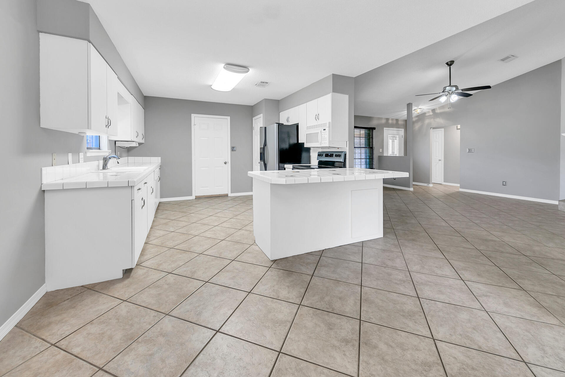 326 Sailfish Circle Destin, FL 32541 - Photo 14 of 28 a kitchen with a sink a stove a microwave and cabinets