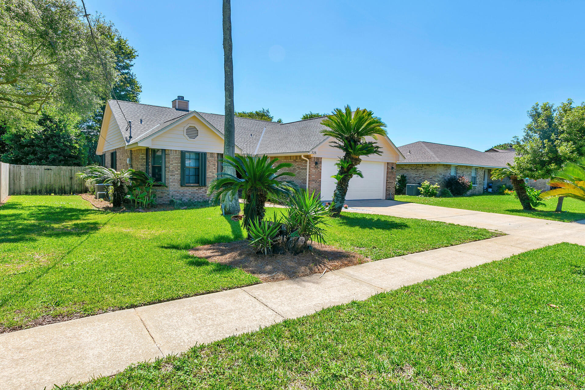 326 Sailfish Circle Destin, FL 32541 - Photo 3 of 28 a front view of a house with a yard and potted plants