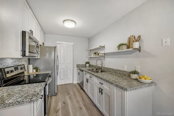 a kitchen with stainless steel appliances granite countertop a sink stove and refrigerator