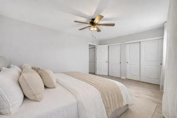 a bedroom with a bed and a ceiling fan