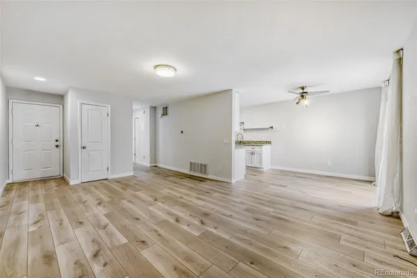 a view of empty room with wooden floor